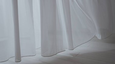 Evde şeffaf tül perdeleri olan pencereler. Şeffaf beyaz ipekten yumuşak kumaşlar. Işığın içinden süzülüyor. Gölgeler ve gölgeler yere yansıyor..