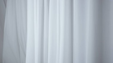 Evde şeffaf tül perdeleri olan pencereler. Şeffaf beyaz ipekten yumuşak kumaşlar. Işığın içinden süzülüyor. Gölgeler ve gölgeler perdelere yansıyor..