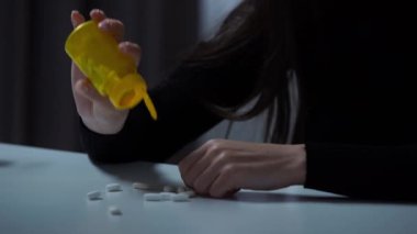 Karanlık dairede depresif bir kadın. Akıl sağlığıyla ilgili sorunları olan bir kadın, kameranın önünde masaya oturuyor, ellerini kapatıyor. İlaçları masaya serer, uyuşturucuya dokunur..