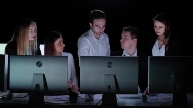 Yönetim kurulu başkanı ve ekibi ofiste çalışıyor. Kadın ve erkek liderler, masalarda monitörlerle, yıllık şirket toplantılarında çalışırlar. Belgeler ve verileri ekranda tartışan üyeler..