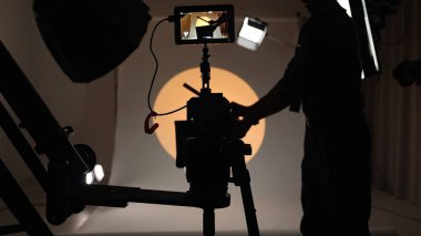 Profesyonel bir stüdyonun içinde. Modern ışıklandırma ekipmanları ve büyük beyaz siklonama ile profesyonel video çekim stüdyosu, alkış tutup alkışlama asistanı.