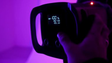 Profesyonel bir stüdyonun ekipmanları. Modern ışıklandırma ekipmanları ile fotoğraf ve video çekimi için profesyonel stüdyo, detayları yakın çekim, ışık ayarlarını değiştiren fotoğrafçı.