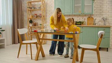 Her gün aile hayatı ve çocuk bakımı. Anne ve kızı mutfakta birlikte, anne kıza zencefilli kurabiye yapmayı öğretiyor, çatal bıçakları açıklıyor ve malzemeleri gösteriyor. Tam çekim.