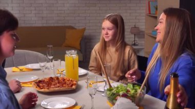 Mutlu aile yıl dönümleri. Aile evde masada oturur, torunlar ve ebeveynler büyükbabanın doğum gününü kutlar, aile üyeleri konuşur ve masada yemek hazırlar..