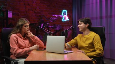 Çevrimiçi yayın. Erkek sunucu ve kadın konuk kayıt stüdyosunda mikrofonlu bir röportaj, dijital içerik yaratmak, sunucu ve kadın masada oturup konuşmak.