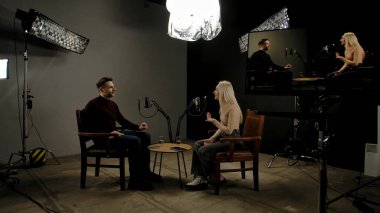 Çevrimiçi podcast gösterisi. Sahne arkası sunucusu ve kadın konuk kayıt stüdyosu şık podcast stüdyosunda röportaj, dijital içerik oluşturma, konuk sunucu.