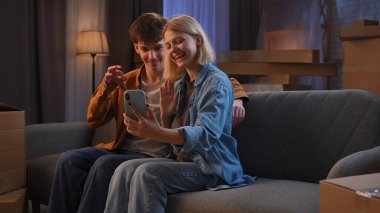 Genç bir adam ve bir kadın oturma odasında bir taşınma partisi hakkında konuşuyorlar. Birbirine aşık bir çift bir kanepede oturmuş yeni evlerini gösteriyorlar..