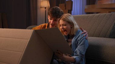 Genç bir adam ve bir kadın oturma odasında bir taşınma partisi hakkında konuşuyorlar. Birbirine aşık bir çift yerde oturmuş, bir karton kutuya bakıyor ve içindekilere hayret ediyor, sonra da öpüşüyorlar..