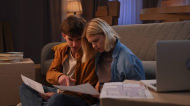 Genç bir adam ve bir kadın oturma odasında bir taşınma partisi hakkında konuşuyorlar. Birbirine aşık bir çift yere oturur ve evleri için yeni bir tasarım hakkında konuşur..