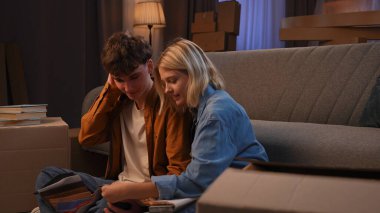 Genç bir adam ve bir kadın oturma odasında bir taşınma partisi hakkında konuşuyorlar. Birbirine aşık bir çift yere oturur ve evleri için yeni bir tasarım hakkında konuşur..