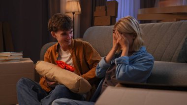 Genç bir adam ve bir kadın oturma odasında bir taşınma partisi hakkında konuşuyorlar. Birbirine aşık bir çift yerde oturuyor, adam kıza sıcak ekose şeklinde bir hediye yapıyor..