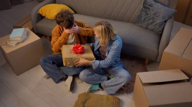 Genç bir adam ve bir kadın oturma odasında bir taşınma partisi hakkında konuşuyorlar. Birbirine aşık bir çift yerde oturuyor, kız vinil plak çalar şeklinde bir hediye veriyor..