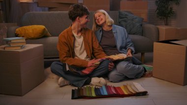 Genç bir adam ve bir kadın oturma odasında bir taşınma partisi hakkında konuşuyorlar. Birbirine aşık bir çift yere oturur ve evleri için yeni bir tasarım hakkında konuşur..