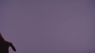 El hareketleri ve işaretleri. Erkek ve kadın elleri jestler gösteriyor ve kalp aşk işareti yapıyor, mor stüdyo arka planında izole edilmiş, yakın çekim. Sevgililer Günü reklam konsepti.