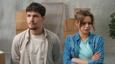 Yeni eve taşınma konsepti. Yeni daireye taşınan genç bir çift, karton kutularla dolu bir yer, yeni dairenin odasında duran erkek ve kadın, olumsuz ifadeleri altüst ediyorlar..