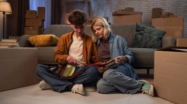 Genç bir adam ve bir kadın oturma odasında bir taşınma partisi hakkında konuşuyorlar. Birbirine aşık bir çift yere oturur ve evleri için yeni bir tasarım hakkında konuşur..