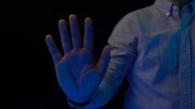 Bilgisayar teknolojisi ve siber uzay güvenliği. Adam cam ekran panele dokunuyor, saydam yüzeyde avuç içi izi var ve model üzerinde mavi ışık var. Dijitalleştirme konsepti şablonu.