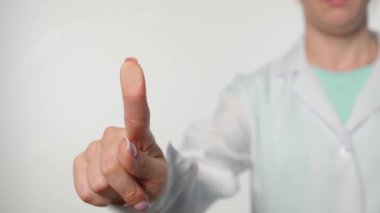 Bilgisayar teknolojisi ve siber uzay yeniliği. Üniformalı kadın doktor cam ekran paneline dokunuyor, saydam yüzey beyaz arka planında parmak izi var. Tıbbın dijital hale getirilme şablonu.