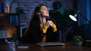 Ofiste çalışan bir iş adamı. Genç iş kadını geç saatlere kadar ofis dairesinde çalışıyor, dizüstü bilgisayar kullanıyor, işini bitirmiş, yüzünü çevirmiş, gülümsüyor..