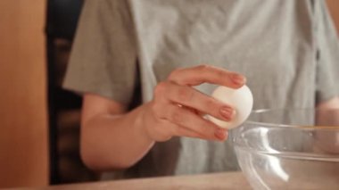 Günlük ev yemeği rutini. Evdeki masada oturan kadın waffle kahvaltısı için hamur hazırlıyor, kasede yumurta kırıyor ve çırpıyor. Yavaş çekim.