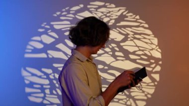 Renkli stüdyo geçmişi olan biri. Not defterinde yazan adamın portresi, spot ışıklarının altında dikiliyor. Mavi turuncu neon üzerinde izole edilmiş. Stüdyo arka planı var..