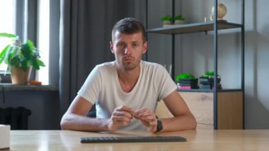 Çevrimiçi kursa katılan kişi. Üniversitede okuyan erkek öğrenci, masa başında oturuyor, bilgisayar dersini izliyor, öğretmenle konuşuyor, soruları cevaplıyor. Modern online eğitim.