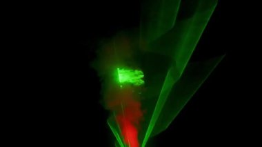 Profesyonel yıldırım teknolojisi konsepti. Dönen yeşil lazer ışını karanlıkta yanıp sönüyor, mavi kırmızı neon dumanında parlayan renkli ışık projektörü, siyah arka planda izole edilmiş.