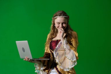 Tarihsel reklam konsepti. Krom anahtar yeşil ekran arka planda antik kıyafetli bir kadın. Rönesans elbisesi giymiş, elinde dizüstü bilgisayarla gülümseyen bir kadın..
