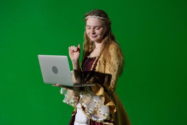 Tarihsel reklam konsepti. Krom anahtar yeşil ekran arka planda antik kıyafetli bir kadın. Rönesans kıyafetli, gülen yüzlü, dizüstü bilgisayarı olan ve tek elle yazan bir kadın..