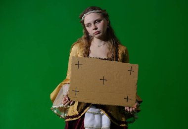 Tarihsel reklam konsepti. Krom anahtar yeşil ekran arka planda antik kıyafetli bir kadın. Rönesans elbiseli, üzgün yüzlü, elinde kameraya poz veren boş bir karton tutan bir kadın..