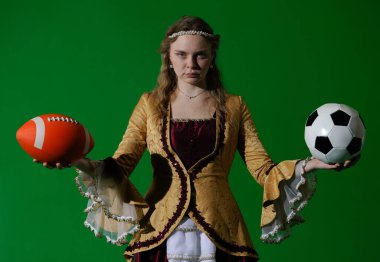 Tarihsel reklam konsepti. Krom anahtar yeşil ekran arka planda antik kıyafetli bir kadın. Rönesans elbisesi giymiş, ciddi yüzlü Amerikan futbolu ve futbol toplarını elinde tutan bir kadın..