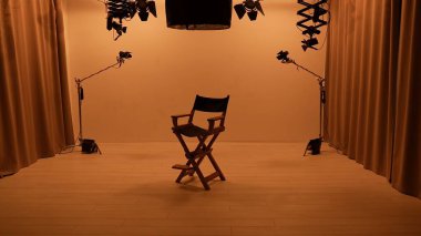 Profesyonel bir stüdyonun içinde. Işık ekipmanları, siklonama ve kamera ile fotoğraf çekimi stüdyoları, ortada yönetmen koltuğu..