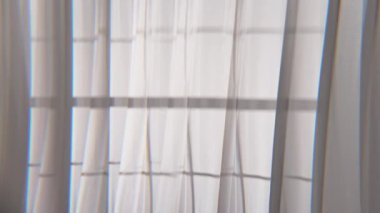 Rüzgarın savurduğu renkli tül kumaşlı pencereler. Gün ışığında şeffaf beyaz ipek perdeler açık bir pencereden süzülen optik efektler, tekstil üzerine yansıyan pencere çerçevesinden gölgeler..