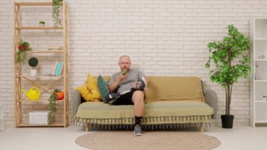 Protez bacaklı bir adam rahat bir oturma odasındaki koltukta oturur ve akıllı telefondan bilgi toplar, mesaj atar. Kısıtlı hareketli adaptif yaşam kavramı.