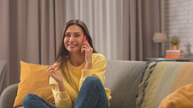 Kadın evde boş vakit geçiriyor. Genç bir kadın bütün gününü evde, oturma odasındaki kanepede oturarak geçiriyor. Telefonlara cevap veriyor, gülüyor, şakalaşıyor, olumlu ifade veriyor..