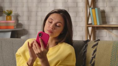 Kadın evde boş vakit geçiriyor. Genç bir kadın bütün gününü evinde, oturma odasındaki kanepede oturarak geçiriyor. Elinde akıllı bir telefonla sosyal medyayı karıştırıyor. İlginç bir yazı görüyor, şaşırmış güzel bir ifade..