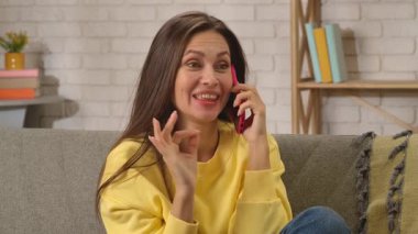 Kadın evde boş vakit geçiriyor. Genç bir kadın bütün gününü evde, oturma odasındaki kanepede oturarak geçiriyor. Akıllı telefondan cevap veriyor, gülümseyen güzel bir yüz ifadesi sergiliyor..