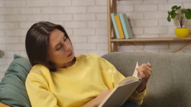 Kadın evde boş vakit geçiriyor. Genç bir kadın bütün gününü evde, oturma odasındaki kanepede oturup elinde bir kitap tutarak roman ya da dedektif okumaktan zevk alarak, sayfaları karıştırarak geçiriyor..