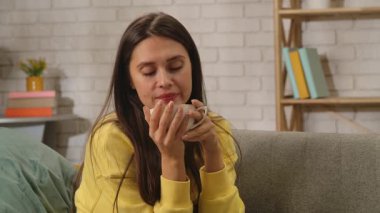 Kadın evde boş vakit geçiriyor. Genç bir kadın bütün gününü evde, oturma odasındaki kanepede oturarak, elinde fincanla çay içerek, etrafa bakınarak, içkiden keyif alarak, olumlu bir ifadeyle geçirir..