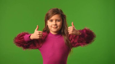 Çocuk duyguları konsepti. Gülümseyen kız kameraya bakar ve el işaretini gösterir, olumlu ifade, krom anahtar yeşil ekran arka plan modelinde izole edilmiş.