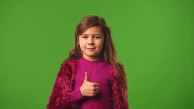 Çocuk duyguları konsepti. Gülümseyen kız kameraya bakar ve el işaretini gösterir, olumlu ifade, krom anahtar yeşil ekran arka plan modelinde izole edilmiş.
