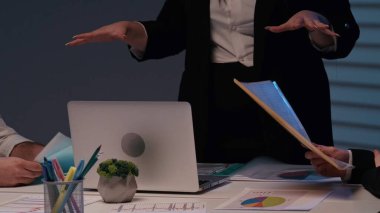 Profesyonellerin finansal tablolar ve raporlar üzerinde tartıştıkları, kurumsal karar verme mekanizmasını ve takım çalışmasını sembolize eden bir iş toplantısının yakın çekimi.