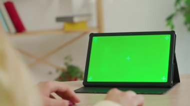 Çevrimiçi kursa katılan kişi. Kadın üniversite öğrencisi evde ders çalışıyor, internetten krom anahtar yeşil ekranlı çalışma alanı modeliyle ders izliyor, kapatıyoruz. Modern online eğitim.