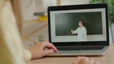 Çevrimiçi kursa katılan kişi. Evde çalışan üniversite öğrencisi, dizüstü bilgisayarda, ekranda ders izleyen öğretmen kara tahtada cebir formüllerini açıklıyor, kapat. Modern online eğitim.