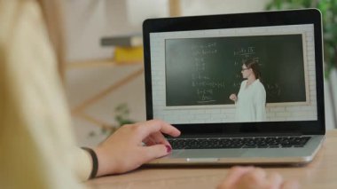 Çevrimiçi kursa katılan kişi. Evde çalışan üniversite öğrencisi, dizüstü bilgisayarda, ekranda ders izleyen öğretmen kara tahtada cebir formüllerini açıklıyor, kapat. Modern online eğitim.