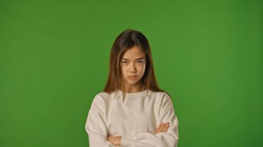 Çocuk duyguları konsepti. Üzgün suratlı Asyalı bir çocuk kameraya bakıyor, negatif yüz ifadesi, krom anahtar yeşil ekranda izole edilmiş, arka plan modeli..
