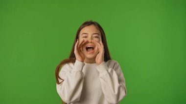Çocuk duyguları konsepti. Asyalı kız çocuğu el ele tutuşup bağırıyor, olumlu ifade veriyor, krom anahtar yeşil ekran stüdyo arka planında izole edilmiş..