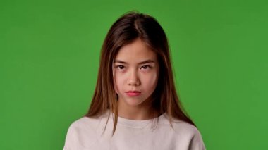 Çocuk duyguları konsepti. Üzgün suratlı Asyalı bir çocuk kameraya bakıyor, negatif yüz ifadesi, krom anahtar yeşil ekranda izole edilmiş, arka plan modeli..