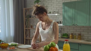 Sağlıklı beslenme konsepti. Mutfaktaki masada genç bir kadın sağlıklı bir öğle yemeği için börek hazırlıyor, ince bir parça alıyor, içine sebze, sebze ve karides koyuyor ve rulo yapıyor..