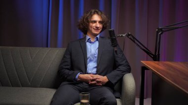 Modern bir podcast stüdyosunda, etkili bir kişi rahat bir şekilde otururken anlayışlı bir röportaj yapar. Bir mikrofon, hikaye anlatırken her kelimeyi yakalar. Burası fikirlerin canlandığı bir yer..